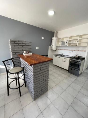 a kitchen with a counter and a table and a chair at Apart Bahia in Bahía Blanca