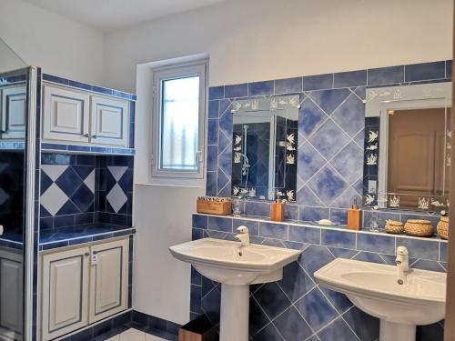 La salle de bains est pourvue de 2 lavabos et de carrelage bleu. dans l'établissement Provence chic, piscine naturelle, détente spa - jacuzzi pour 2, à Besse-sur-Issole