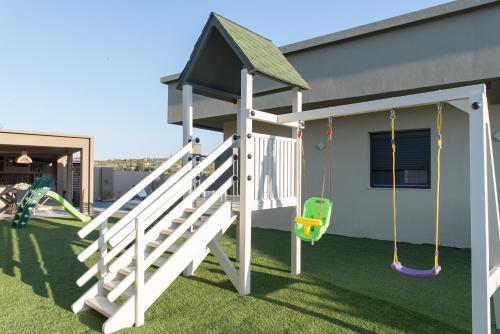 a house with a playground with a slide and swings at Minas Sublime Villa, a Magical Sanctuary, By ThinkVilla in Kipseli