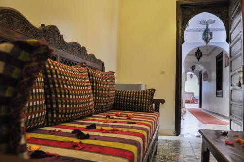 a couch with a colorful blanket on it in a room at Riad Jibril in Marrakech