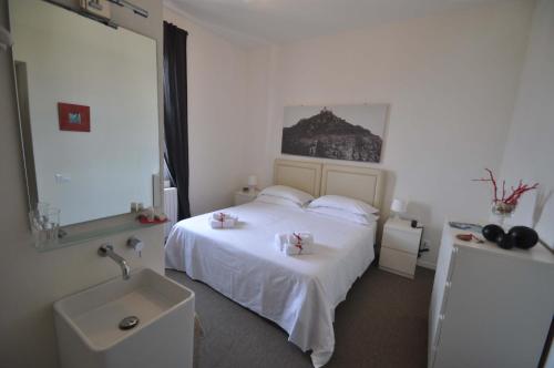 クエルチアネッラにあるHotel Belsoggiornoのベッドルーム(白いベッド1台、シンク付)