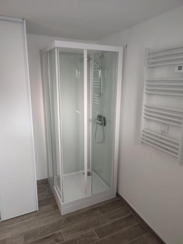 - une cabine de douche en verre dans une pièce blanche dans l'établissement Charmante petite maison cosy style industriel, à Longuenesse