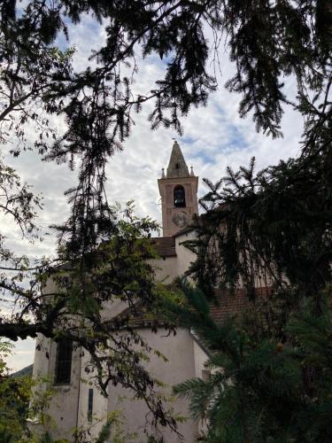 a building with a clock tower on top of it at Piccola Navetta in Diano San Pietro