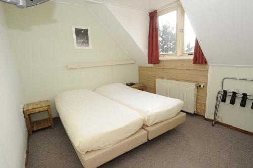 ein Schlafzimmer mit einem weißen Bett in einem Zimmer in der Unterkunft Hotel De Horper Wielen in Kaard