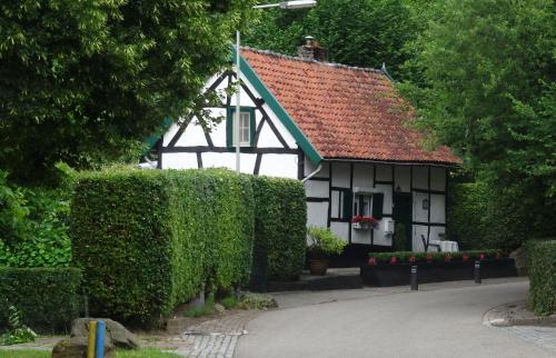 a white and black house with a red roof at B&B Vroelen-Noorbeek in Noorbeek