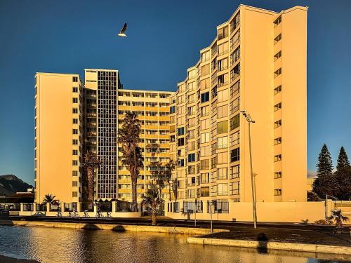 un grand bâtiment avec un oiseau survolant une rivière dans l'établissement Ashley on Beach, à Strand