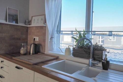 Stylish apartment with 2 bedrooms في Eyrarbakki: طاولة مطبخ مع حوض ونافذة