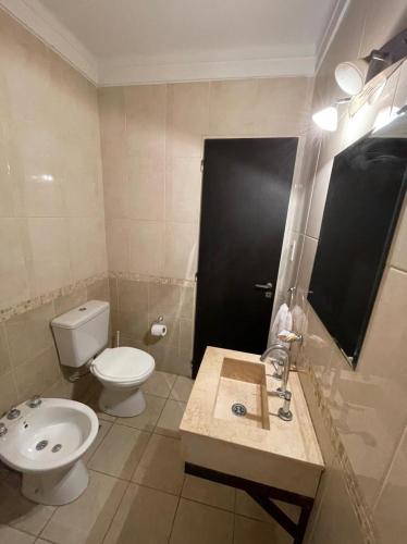 a bathroom with a toilet and a sink at Apart Bahia in Bahía Blanca