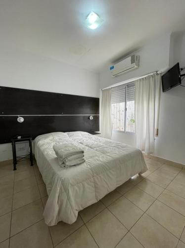 a bedroom with a large white bed with a black headboard at Apart Bahia in Bahía Blanca