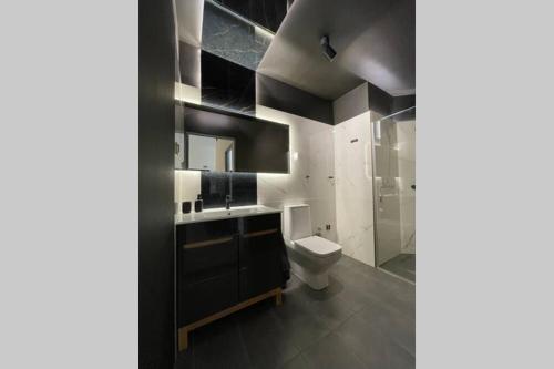een badkamer met een toilet, een wastafel en een spiegel bij DarkHouse2 in Łódź