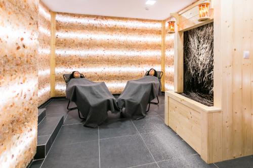 two people sitting in chairs in a room with a wall at ASTORIA Hotel & Medical Spa in Karlovy Vary