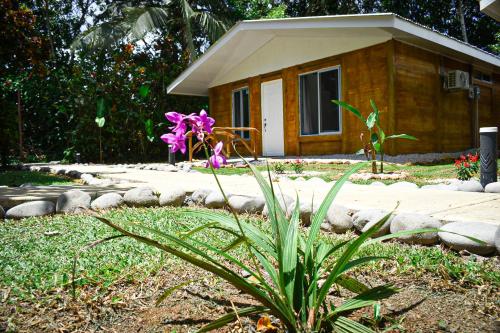a small house with purple flowers in front of it at Tropical Paradise Bungalows in Pital