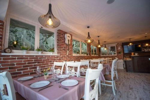 una sala da pranzo con tavolo e sedie bianche di PULPUDEVA Family Hotel a Plovdiv