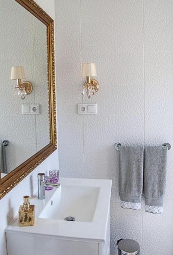 a white bathroom with a sink and a mirror at Casa Pedro e Inês in Viana do Castelo
