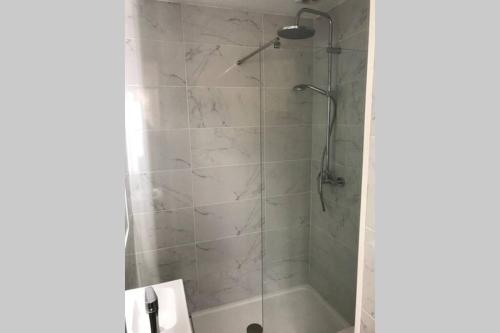 une salle de bain avec une douche avec une porte vitrée dans l'établissement charmant studio bord de mer, à Menton