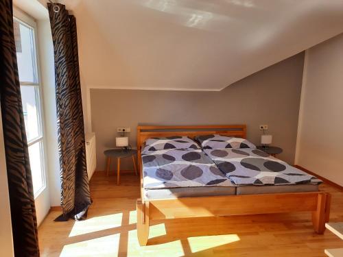ein Schlafzimmer mit einem Bett und zwei Fenstern in der Unterkunft Ferienwohnung Berger in Gmünd in Kärnten