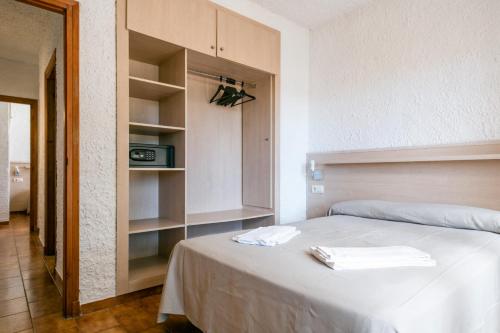 1 dormitorio con 1 cama con toallas en Rentalmar El Pinar Adosados, en Miami Platja