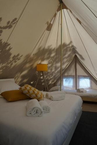 1 dormitorio con tienda de campaña y toallas en una cama en Dimore Montane, en Roccamorice