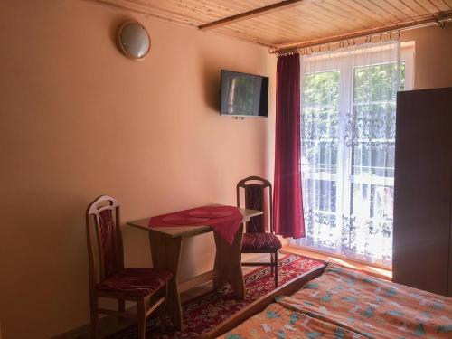 a dining room with a table and chairs and a window at Anna Maria II in Jastrzębia Góra