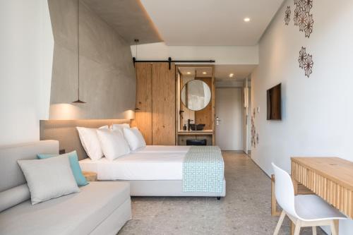 Habitación de hotel con cama y sofá en Sensus Experience by Lavris en Gouves