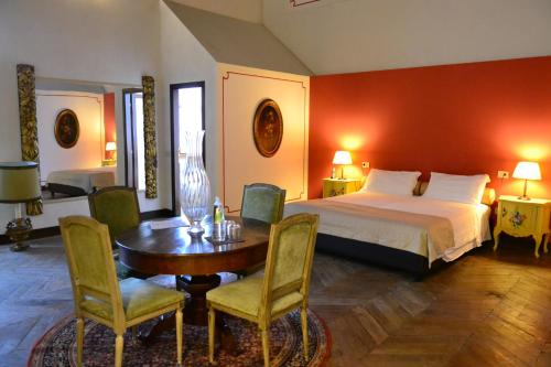 a bedroom with a bed and a table and chairs at Castello Di Compiano Hotel Relais Museum in Compiano