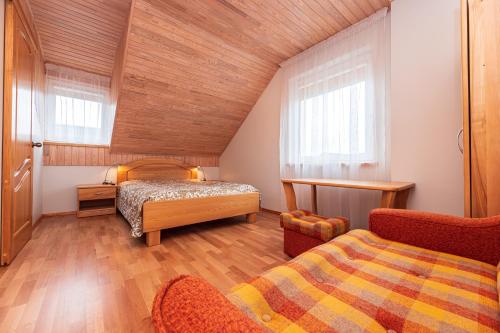 una camera da letto mansardata con due letti e una sedia di Vila Arona a Palanga