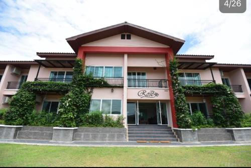 a large building with plants on the side of it at Rose Villa Hote in Pak Chong