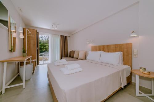 a bedroom with a large white bed with white pillows at Alion apartments in Prinos