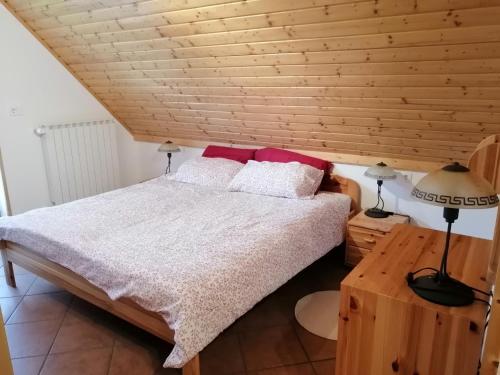 - une chambre avec un lit et un plafond en bois dans l'établissement Počitniško stanovanje PLANJA, à Vallée de la Soča