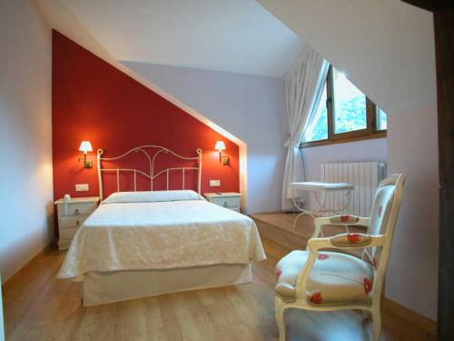 a bedroom with a bed and a red wall at Hotel Cosgaya in Cosgaya