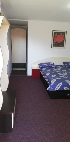 a bedroom with a bed and a cabinet in it at Pensiune Piatra Mare in Nehoiu