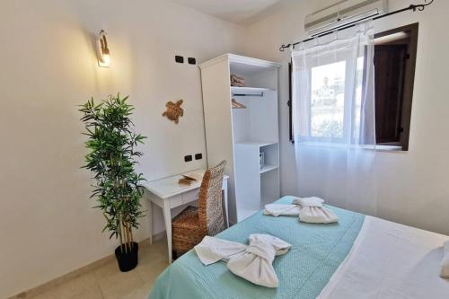 a room with a bed and a table with towels at Loft Tropical - 100 metri dalla spiaggia di sabbia e dal mare in Fontane Bianche