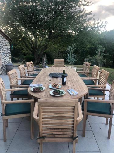 une table et des chaises en bois avec des assiettes de nourriture dans l'établissement Le Cerisier Saint-Barbant, à Saint-Barbant