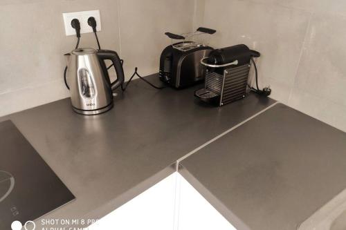 a counter top with a toaster and a toaster and a blender at Old Town House in Loulé