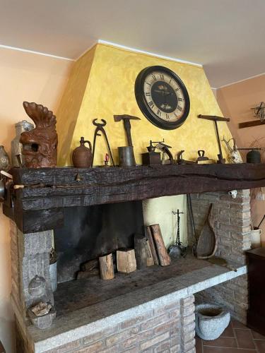 a fireplace with a clock on top of it at Al Vecchio Camino in Rotonda