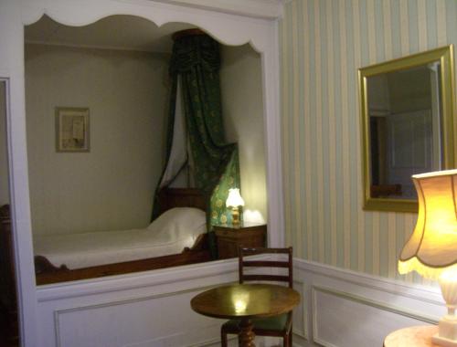 a bedroom with a bed with a mirror and a table at Le Chateau de Prauthoy in Prauthoy