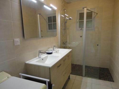 une salle de bain avec un lavabo et une douche dans l'établissement MAISON PROXIMITE COMMERCES, à Saint-Jean-de-Monts