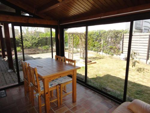 - une table et des chaises en bois sur une terrasse couverte dans l'établissement MAISON PROXIMITE COMMERCES, à Saint-Jean-de-Monts