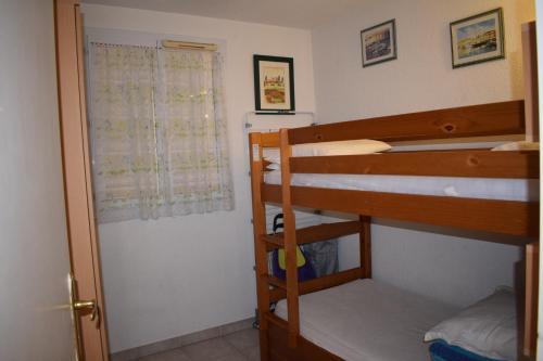 une chambre avec deux lits superposés et une fenêtre dans l'établissement Appartement à Fréjus 2 pièces pour 4 personnes, terrasse avec vue piscine, à Fréjus