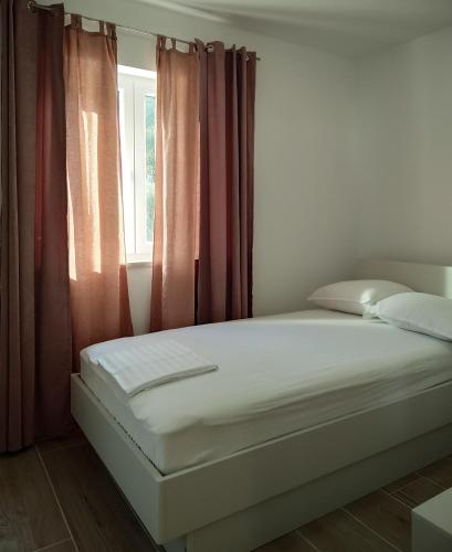 a white bed in a room with a window at Strawberry in Bol