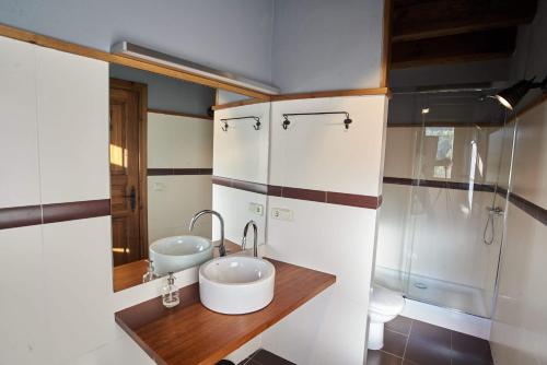 ein Bad mit 2 Waschbecken und einer Dusche in der Unterkunft PRECIOSA CASA, NAUT ARAN, ALTO ARAN, GESSA, A 4 KM DE BAQUEIRA, 212 M2 wifi in Gessa