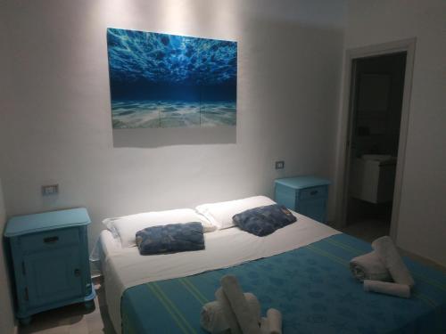 a bedroom with a bed and a painting on the wall at Casa in borgo marinaro in Giardini Naxos