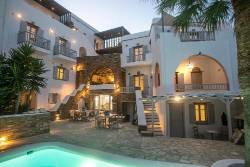 une villa avec une piscine en face d'un bâtiment dans l'établissement Onar Hotel & Suites, à Tinos