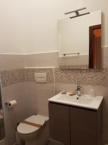 a bathroom with a toilet and a sink and a mirror at Hotel La Torre in Cogoleto