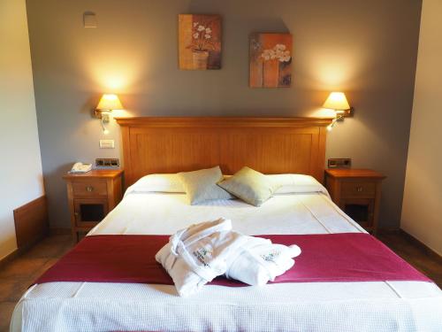 a bedroom with a bed with towels on it at Hotel & SPA Peña Montañesa in Aínsa