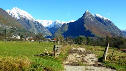 a fence in a field with mountains in the background at Hiša Lojz in Žaga