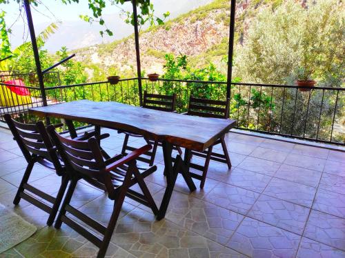 een houten tafel en 2 stoelen op een balkon bij Likya SUP Apart in Kas