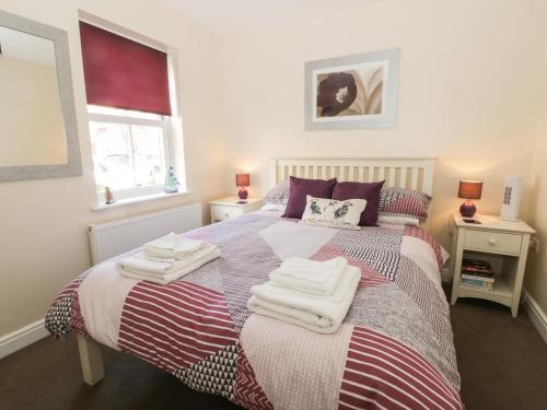een slaapkamer met een bed met handdoeken erop bij Northolme in Filey