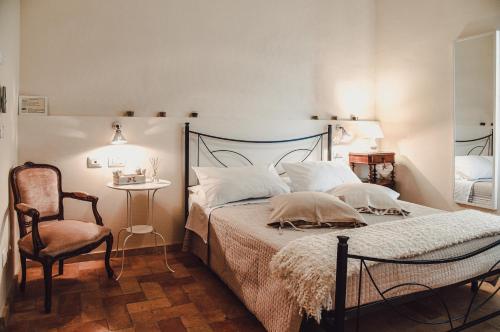 a bedroom with a bed and a chair and a table at Masseria del Vino in Loreto Aprutino