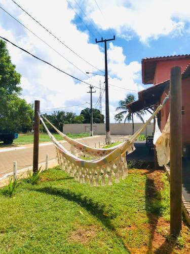 a hammock hanging from a pole next to a building at Pousada Morro do Pico in Fernando de Noronha